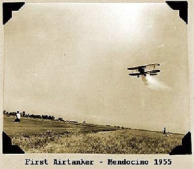 A sepia photograph of a biplane flying low over a field trailing a plume of water, captioned First Airtanker, Mendocino 1955