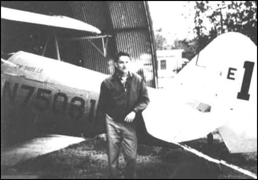 A man stands beside the tail of the Stearman biplane N75081